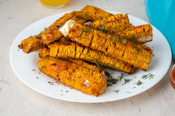 Grilled corn on the cob cooked with barbecue sauce and grilling spices, close-up.