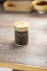 Glass jar with scented cloves vintage kitchen wooden table top