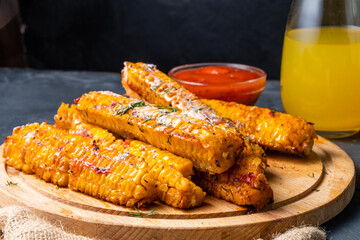 Grilled corn on the cob with spices and butter with herbs and salt. Close-up