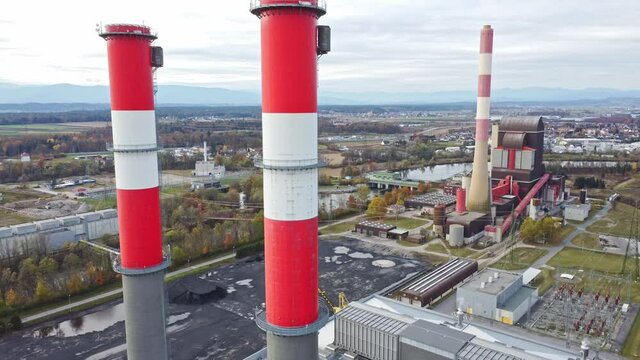 Descending flight along an industrial chimney at a gas power station with an old coal power station in the background