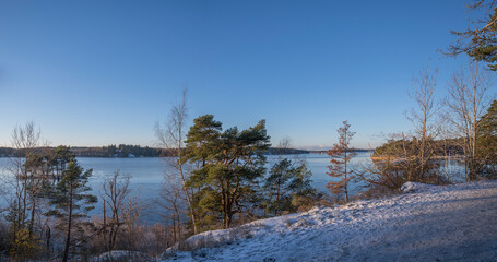 View point from a walkway with snow and an icy lake Mälaren a sunny pale winter day with snow in Stockholm