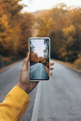 person holding a phone in autumn