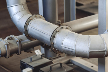 Part of a curved pipe. Connections on pipes. Bolts. Industry.