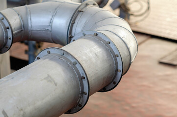 Part of a curved pipe. Connections on pipes. Bolts. Industry.
