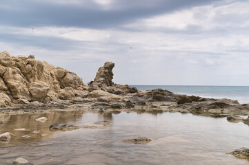 beach with rocks, waves and foam in the town of Campello, Alicante province, Spain