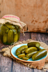  Plate of  homemade  organic bio pickled cucumbers  in vinegar with dill ,garlic and mustard seeds against dark rustic background
