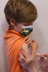 Chłopiec przyjmujący szczepionkę przeciwko Covid