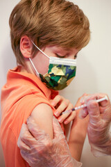 Chłopiec przyjmujący szczepionkę przeciwko Covid - obrazy, fototapety, plakaty