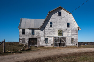 Fototapeta na wymiar old abandoned rural horse barn on farm