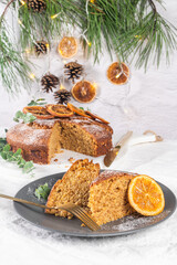 Fototapeta na wymiar Christmas orange and spice cake. Decorated with dried oranges on kitchen countertop