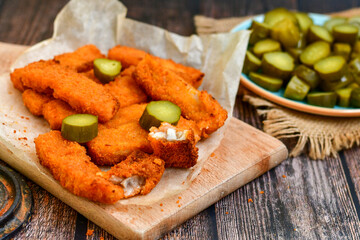 Close up of   Crispy breaded  deep fried fish fingers with breadcrumbs served  with remoulade sauce and  lemon Cod Fish Nuggets on rustic wood table background
