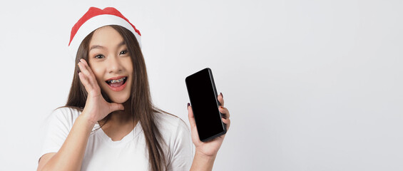 Woman and smartphone. Asian woman with smartphone in hand which posing like selfie or video call for online celebration in Christmas and new year festival season. Teenage braces happy and smartphone.