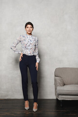 Young model woman in trendy blouse, trousers and in high heels shoes