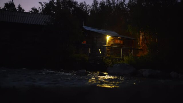 Cozy country house at night on the riverbank