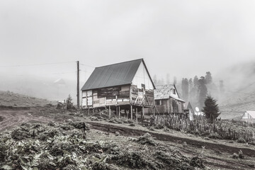 Unfinished wooden house standing in a foggy field