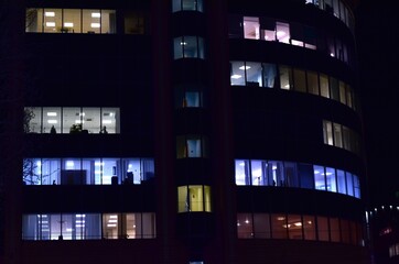 High-rise building illuminated by numerous windows at night.