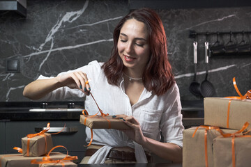 redhead woman is surprised as she opens recyclable gift boxes, happy redhead woman opening her presents, excited redhead woman looking at her gifts wrapped in recyclable paper