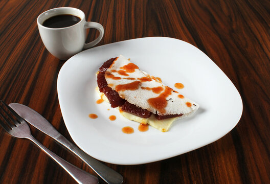 Brazilian food. Tapioca stuffed with guava paste and white cheese with a cup of black coffee.