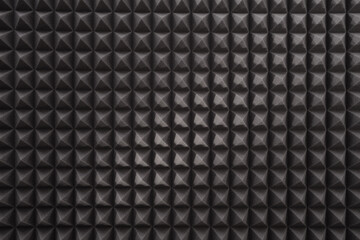 Triangular acoustic foam rubber. Sound proof pattern texture wall in sound studio. Background of sound absorbing sponge.