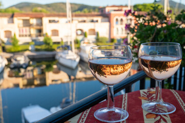 Drinking of local rose wine in summer with sail boats haven of Port Grimaud on background, Provence, France