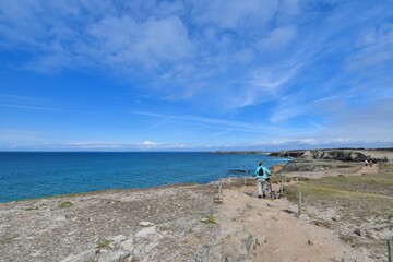 Woman with her bicycle walking along the wild coast of the Quiberon peninsula in Brittany France
