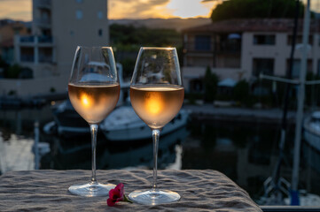 Obraz premium Tasting of local rose wine in summer with sail boats haven of Port Grimaud on background, Provence, France