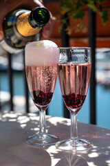 Summer party with sparkling rose champagne wine and sail boats haven of Port Grimaud on background, Provence, France