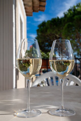 Tasting of local white wine on sunny summer balcony Provence, France