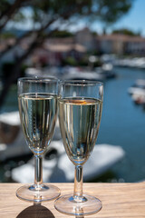 Summer party with sparkling champagne wine and sail boats haven of Port Grimaud on background, Provence, France