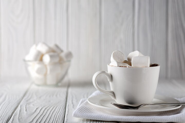 Mug with hot chocolate and marshmallows on wooden table