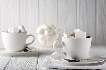 Mug with hot chocolate and marshmallows on wooden table