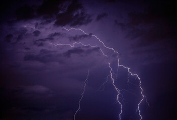 Night lightning thunderbolt over the sky in blue background