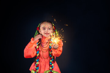 Mexican girl with orange rebozo blouse and braids celebrating a Mexican posada with candles and...