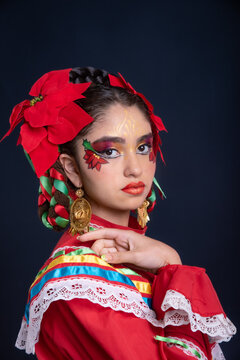 Mexican teenager with red dress and facial makeup rebozo and sparklers celebrating Mexican Christmas and traditional posada of the Mexican Christmas holidays