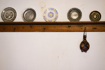 A set of old-fashioned plates arranged on a white kitchen wall
