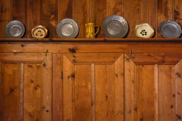 A set of old-fashioned plates arranged on a wooden kitchen wall
