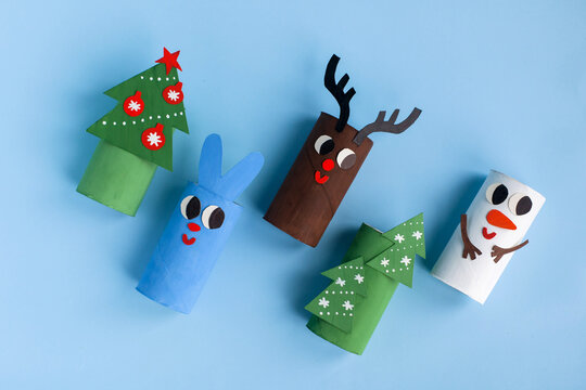 Holiday easy DIY idea for kids. Toilet paper roll tube toy Christmas tree, snowman, rabbit, deer on blue background. New Year decoration eco-friendly, recycle handmade concept. flat lay, top view