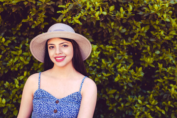 Young woman portrait at park with summer look wearing a hat