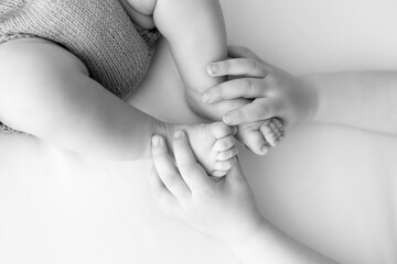 Newborn feet in child's hands