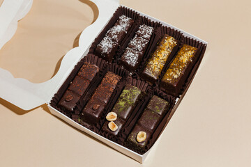 closeup various handmade vegan chocolate candies n the gift box on yellow background