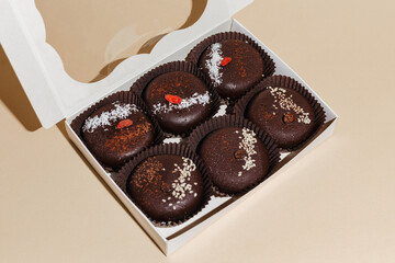 closeup various handmade vegan chocolate cakes in the gift box on yellow background