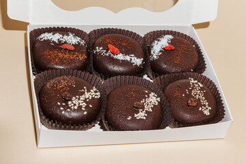 closeup various handmade vegan chocolate cakes in the gift box on yellow background