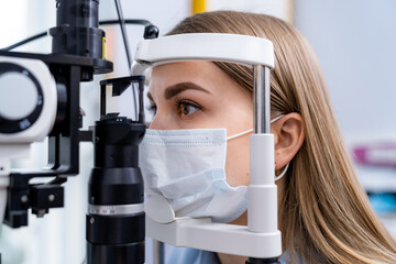 Female patient is checking her eye vision in ophthalmology modern clinic. Woman in ophthalmology...