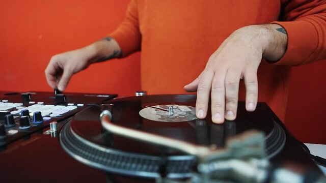 Hip hop dj scratching vinyl record disc with music on retro turntables