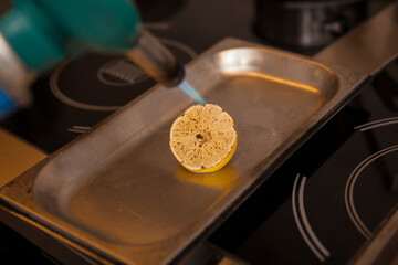 Close up of a hef using blowtorch on a lemon