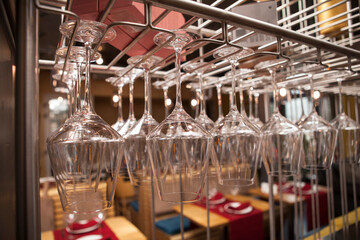 Close up of a stemware rack at restaurant full of clean glasses