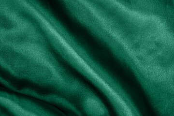Obraz premium Elegant smooth green silk or satin folds closeup. Cloth texture background. Abstract wallpaper. Trendy mint green backdrop for web design. Luxury twisted fabric backplate 