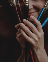 Young beautiful girl, the artist holds paintbrushes in her hands.	
