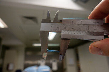  blue titanium screw is measured with a caliper gauge