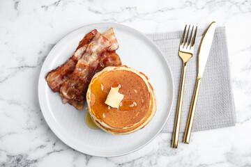 Delicious pancakes with maple syrup, butter and fried bacon on white marble table, flat lay - obrazy, fototapety, plakaty